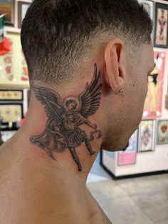 a man with a skull and angel tattoo on his neck