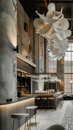 the interior of a restaurant with tables, chairs and lights hanging from the ceiling above