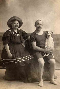 an old black and white photo of two people with a dog