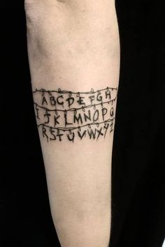 a person with a tattoo on their arm that has letters and numbers written in black ink