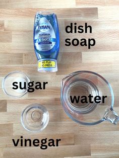 the ingredients to make dish soap are displayed on a wooden surface, including vinegar, sugar and water