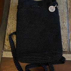 a black bag with a white tag on it sitting on the floor next to a door