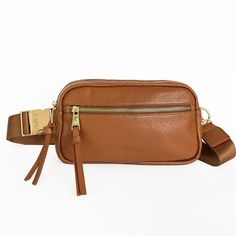 Whether you're walking around town, at a sporting event, or out to dinner, the Hampton is perfect for when you want to be hands-free. It fits all your essentials and has an adjustable strap to go from crossbody to waist bag for two looks in one! HIGHLIGHTS Dune Tan color Luxury genuine perforated leather  9.5" W X 5.5" H X 2.5" D Shore Pine green lining Custom gold hardware with solid metal buckle Exterior front pocket: perfect for your phone or keys Interior card slot Interior leather trimmed p Brown Belt Bag With Detachable Strap For On-the-go, Versatile Belt Bag For On-the-go, Modern Crossbody Chest Bag With Detachable Strap, Versatile Chest Bag With Detachable Strap For On-the-go, Versatile Chest Bag With Detachable Strap, Modern Crossbody Belt Bag For On-the-go, Crossbody Belt Bag With Adjustable Strap For On-the-go, Brown Functional Belt Bag For Travel, Functional Brown Belt Bag For Travel