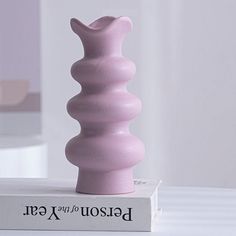 a pink vase sitting on top of a box