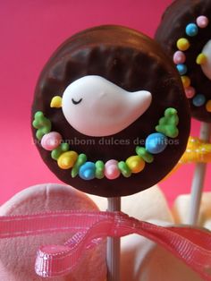 two chocolate lollipops decorated with candy beads and a sleeping monkey on top