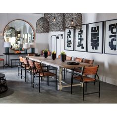 a dining room table with chairs and pictures on the wall behind it, along with other furniture