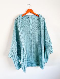 a blue sweater hanging on a white wall