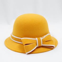 a yellow hat with a big bow on the front and white ribbon around the brim