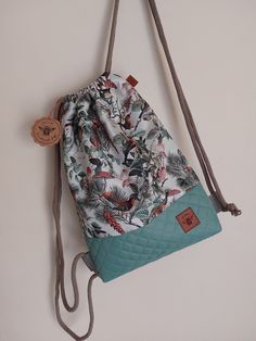 a purse hanging on a wall with a tag attached to the front and side of it