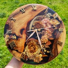 a clock made out of wood with flowers and roman numerals on the face