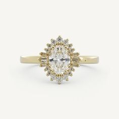 a yellow gold engagement ring with an oval cut diamond surrounded by baguettes on the band