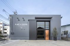 an empty parking lot in front of a building with a sign that says art of coffee