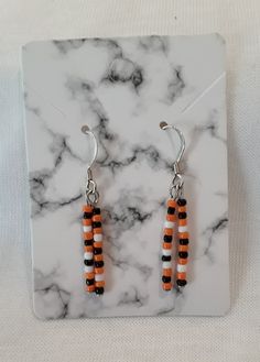 Halloween Earrings.  Beaded glass earrings alternating orange, black and white dangle from silver wires.  Two rows of beads hang from each wire swaying freely with Halloween colors.  These earrings are great to wear in October for the Halloween spirit, but also can be worn with everyday colors of orange or black.  Costume Earrings, Trick or Treat earrings, fun earrings, Fall Earrings. Purchase yourself or as a gift, think Teacher gift or just to say a Halloween "Thank You".  Handmade earrings  and FREE SHIPPING! Orange Dangle Beaded Earrings With Black Beads, Orange Dangle Earrings With Black Beads, Orange And Black Beads Dangle Earrings, Orange Earrings With Black Beads For Gift, Orange Earrings With Black Beads As Gift, Orange Dangle Jewelry With Black Beads, White Drop Earrings With Black Beads, Halloween Bead Earrings, Fall Earrings Diy