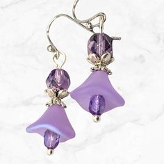 Lavender and purple earrings made with Czech glass flower beads. Beautiful frosted lavender glass flowers dangle beneath purple and silver accents. Great for a special event like prom or bridesmaid earrings, or simply to add a pop of color to your everyday look. Light weight and comfortable for all day wear.  Hypoallergenic ear wires (nickel and lead free). Select ear wire style at checkout.  Free gift packaging included. Artisan glass beads produced in small quantities in the Czech Republic Lin Prom Jewelry Earrings, Glass Flower Earrings, Purple Dangle Earrings, Czech Glass Jewelry, Lavender Earrings, Purple Prom Dress, Lavender Flower, Reno Nv, Earrings Purple