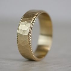 a gold wedding ring with intricate details on it