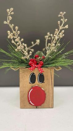 a wooden block with a red nose and green plants in it