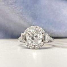 This item has just been reserved by another customer. Please contact us to be notified if it becomes available.  The main feature of this handcrafted platinum setting is an antique European cut diamonds, dating back to 1920, weigh about 1.75 carats with J color and VS1 clarity. It is surrounded by a halo of diamonds and complemented on both sides with baguette-cut diamonds. The shoulders of the mounting are adorned with additional diamonds and the lower gallery features a delicate scroll motif d European Cut Diamond Ring, Estate Diamond Jewelry, Bling Ring, Ring Halo, Jewelry Style, Baguette Cut Diamond, Wedding Rings Vintage, Motif Design, Bling Rings