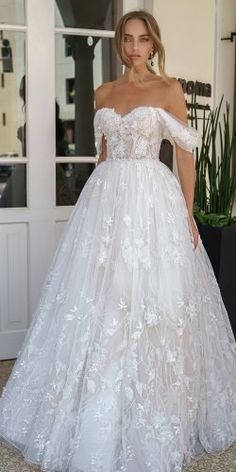 a woman in a white wedding dress standing outside