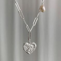 VAIGE Dainty Paperclip Silver Irregular Texture Heart Pearl Lariat Necklace Discover the perfect blend of elegance and charm with our Dainty Paperclip Silver Irregular Texture Heart Pearl Lariat Necklace. This exquisite piece is designed for the modern individual who appreciates unique fashion statements. Key Features: High-Quality Materials: Crafted from premium copper, ensuring durability and a lasting shine. Unique Design: The irregular texture and heart motif create a one-of-a-kind accessory Elegant Lariat Heart Charm Necklace, Elegant Heart-shaped Lariat Necklace With Clavicle Chain, Elegant Heart Shaped Lariat Necklace With Clavicle Chain, Elegant Heart Necklace With Paperclip Chain, Elegant Heart-shaped Paperclip Chain Jewelry, Silver Lariat Necklace With Paperclip Chain For Gift, Elegant Jewelry With Heart Pendant And Paperclip Chain, Elegant Heart-shaped Lariat Necklace For Anniversary, Elegant Heart Pendant Jewelry With Paperclip Chain