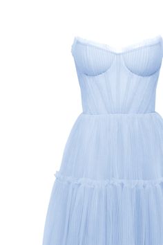 Dreamy tulle dress in light blue color with a light ruffled tulle maxi skirt. This dress has a heart-shaped boned semi-transparent bodice with built-in cups and a corset back, which makes the silhouette fitted and elegant. The A-line maxi skirt is made from multiple layers of delicate tulle that emphasize the hourglass silhouette. The waistline is adorned with a silver belt with Milla’s signature. Details: Material: Tulle Fabric composition: 100% Polyester, 100% Nylon Sleeve style: Sleeveless Silhouette: A-line Skirt length from waist: 116 cm / 45.6 inches Dress weight: 1.14 kg / 2.5 lbs Neckline: Heart-shaped neckline Back: Lacing closure Lining: Light blue full-length flared underskirt Model is: 180 cm / 83-60-95, wearing size S Art.N.: 9000-10 Light Blue Summer Tulle Dresses With Fitted Bodice, Prom Dresses With Ruffled Midi-length Skirt, Prom Dresses With Ruffled Skirt In Midi Length, Prom Dresses With Ruffled Midi Skirt, Prom Dresses With Ruffled Skirt And Midi Length, Summer Evening Dress With Fitted Bodice In Tulle, Sheer Tulle Evening Dress For Summer, Blue Tulle Dress With Lined Bodice, Summer Gala Dress With Voluminous Skirt