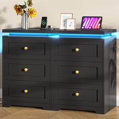 a black dresser with gold knobs and blue lights on it's sides is shown