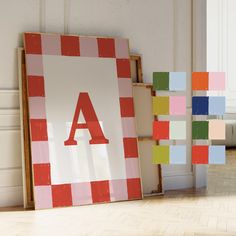 two frames with letters are next to each other on the floor in an empty room