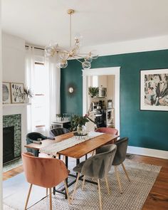 a dining room with green walls and chairs