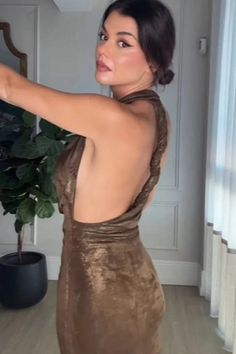 a woman in a brown dress taking a selfie