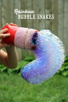 a child holding up a rainbow bubble snake toy in the air with text overlay reading rainbow bubble snakes