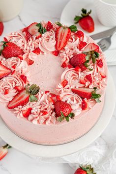 a strawberry cake with pink frosting and fresh strawberries on top, ready to be eaten