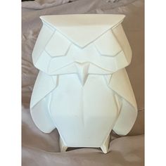 an owl shaped vase sitting on top of a bed