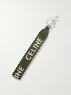 an olive green keychain with the words live genee printed on it, hanging from a metal hook