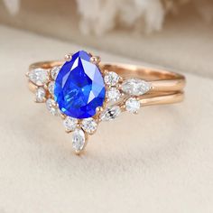 a close up of a ring with a blue stone in the middle and white diamonds around it