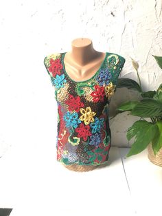 This beautiful sleeveless crochet blouse is handcrafted. The intricate design and attention to detail took a long time to create, resulting in a truly unique and one-of-a-kind piece. This blouse is perfect for any occasion, whether dressed up with a skirt or dressed down with jeans. Measurements:     Chest: 32,3 inches/82 cm     Length: 22,8 inches/58 cm Green Sleeveless Crochet Top With Crochet Trim, Green Cotton Crochet Top With Crochet Trim, Multicolor Lace Tops For Spring, Multicolor Sleeveless Crochet Dress With Crochet Trim, Green Crochet Lace Cotton Top, Bohemian Crochet Multicolor Tank Top, Multicolor Crochet Lace Sleeveless Dress, Handmade Lace Crochet Dress, Multicolor Sleeveless Crochet Lace Dress