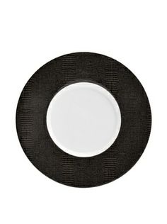 a black and white plate with an oval design on the rim, against a white background