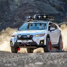 a white car driving down a dirt road