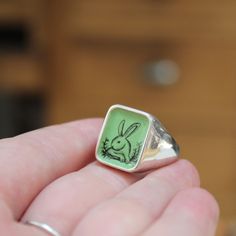 This rabbit ring has a vintage feel both in color and drawing style. it's unique and masculine with a hidden banner message on the underside reminding you to "follow your heart" .Built for comfort, this hefty sterling silver signet ring looks great on a pinky finger or wear it big and bold on your ring , middle or index finger.My original drawing is screen printed and fired on three layers of vitreous enamel at 1400 degrees making for a waterproof, durable and vibrant finish. The face of the rin Personalized Enamel Ring As Gift, Personalized Enamel Ring For Gift, Personalized Enamel Rings As Gifts, Personalized Enamel Rings For Gifts, Engraved Enamel Ring As A Gift, Engraved Enamel Ring As Gift, Engraved Enamel Ring For Gift, Vintage Stamped Engraved Ring For Gift, Vintage Engraved Ring For Gift