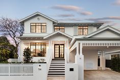 a large white house with black and white steps leading up to it's front door