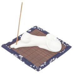 a white dog bone sitting on top of a mat with a toothpick in it