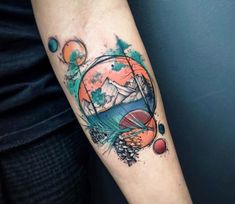 a person with a tattoo on their arm that has mountains and trees in the background