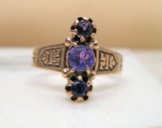 This is a fantastic 1800s Victorian ring with a unique design done in 12k Rose gold.    There are 3 amethyst running down the ring North South.  They all have rich purple color.  The center measures approximately 4.5mm and the top and bottom are 3.4 - 3.5mm.   On each shoulder there is a nice Victorian engraved design.  The top of the ring measures 14.75mm so it has nice size. It is a finger size of 6.25 currently and it can be sized.  The ring weighs 3 grams, solid and well made.  It has been tested for 12k.  There is a stamp, most likely British but I can't make out what it is.    This  ring is so pretty, this is an outstanding design, very well done and unique.     This would make a really special right hand ring, collectible and full of history. occasion.  I have been selling jewelry f Victorian Style Purple Ring In 14k Gold, Victorian Style 14k Gold Rings In Purple, Victorian Style Hallmarked Purple Rings, Victorian 14k Gold Purple Rings, Victorian Purple Hallmarked Ring, 1800s Jewelry, Amethyst Gem, Right Hand Rings, Victorian Rings