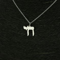 This exquisite Chai pendant is an original work of art that combines the timeless elegance of a traditional decorative motif with a beautiful contemporary design.  Containing the Hebrew letters Chet and Yud to spell out the word Chai, meaning Life. The word Chai is a common expression in Judaica to express the Jewish value of life, both in this world and eternal spiritual life.  Made from high quality sterling silver - 20mm diameter, the Jewish Chai Pendant is a durable and long-lasting accessory. This necklace is also a thoughtful and meaningful gift for anyone who values their Jewish heritage and wants to stay connected to their faith. It's perfect for birthdays, bat mitzvahs, Hanukkah, or any other special occasion. So why wait? Order your Jewish Chai Necklace today and experience the b Symbolic Sterling Silver Pendant Necklace, Sterling Silver Symbolic Pendant Necklace, Sterling Silver Star Of David Amulet Necklace, White Gold Amulet Necklace As Gift, White Gold Engraved Star Of David Necklace, White Sterling Silver Symbolic Necklace, Engraved Sterling Silver Star Of David Necklace, Traditional Pendant Charm Necklace As Gift, Traditional Pendant Necklaces Personalized