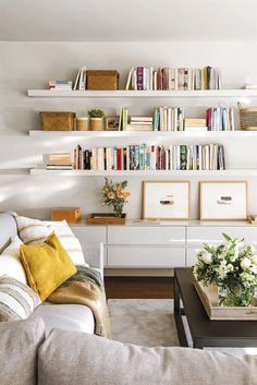 a living room filled with furniture and lots of books on the shelves over the couch