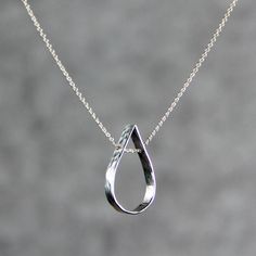 This simple teardrop pendant necklace is handmade and hand stamped using sterling silver. Slim, sheer, barely-there pendant for everyday wear. I've hand-hammered these shiny sequin dangles texture to give them a bit of sparkle. The teardrop stands for the inresistable natural gravitational force. It implies the softness of water. It is gravitating, playful and feminine. ;-) My contact number: 626-379-1904. Please contact me if you would like to order multiples or customize a design for your spec Gravitational Force, Silver Necklace Designs, Handmade Jewelry Necklace, Silver Jewelry Design, Wedding Gifts For Bridesmaids, Spiral Earrings, Gold Filled Earrings, Teardrop Pendant, Silver Jewelry Handmade