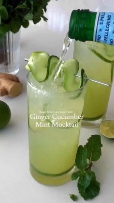 two glasses filled with lemonade and limes on top of a white countertop