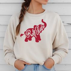 Get ready for game day and show your team pride with our Roll Tide Elephant Football Sweatshirt! This warm and cozy crewneck sweater is perfect for any Alabama fan. Whether you're cheering in the stands or watching from home, you'll be the most stylish fan in this Roll Tide sweatshirt. Sporty Crew Neck Top For Tailgating, Team Spirit Tops For Tailgating With Crew Neck, Team Spirit Crew Neck Top For Tailgating, Tailgating Team Spirit Crew Neck Tops, Collegiate Sweater For Game Day In Fall, Collegiate Fall Sweater For Game Day, Collegiate Style Sweater For Game Day In Fall, Casual Crew Neck Tops For Tailgating, Red Team Spirit Sweatshirt For Game Day