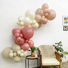 there are balloons hanging on the wall above a chair and potted plant in this room