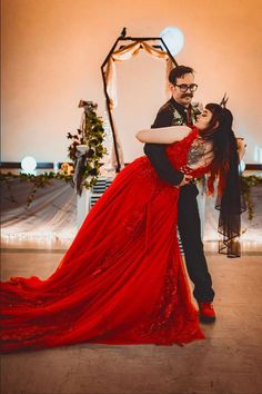 a man and woman in red dress dancing