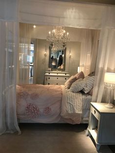 a bedroom with a chandelier hanging from the ceiling and a bed in front of it