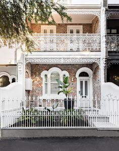 an old brick house with white balconies and iron railings on the front